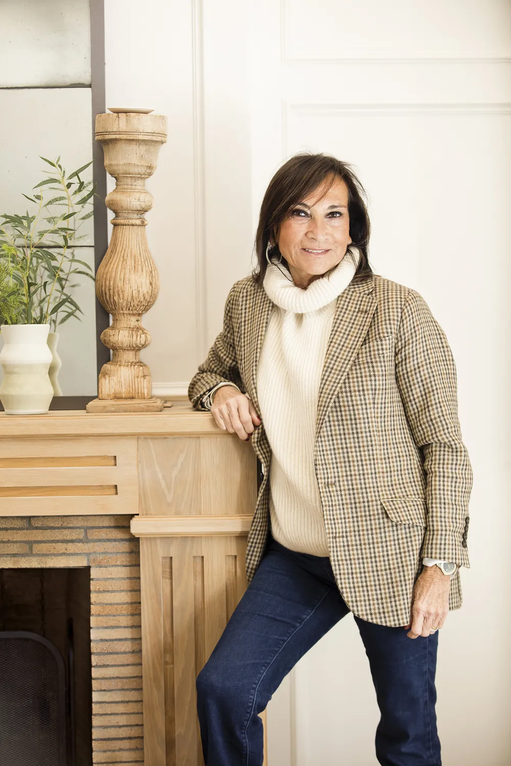 Asun Antó, fundadora y directora de Coton et Bois, apoyada en la chimenea de una vivienda reformada por el estudio